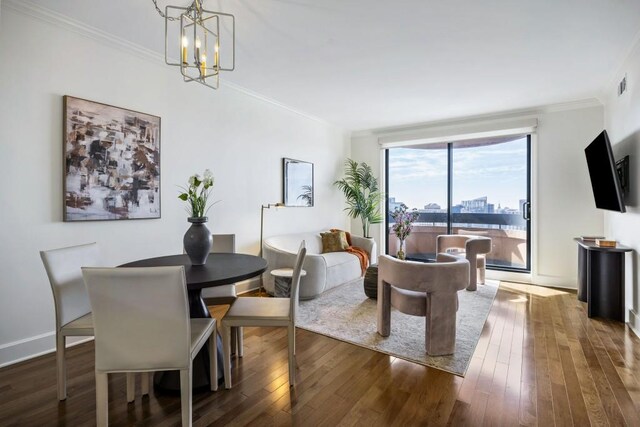 dining space with an inviting chandelier, crown molding, wood finished floors, and baseboards