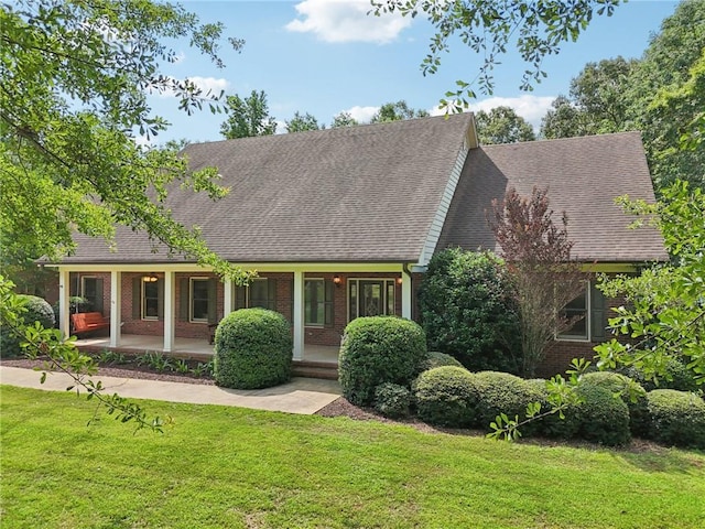169 Robson Trl, Mcdonough, GA 30252 - cape cod home featuring brick siding, a shingled roof, a front yard, and covered porch
