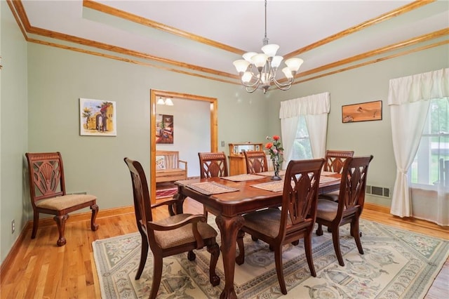 169 Robson Trl, Mcdonough, GA 30252 - dining area featuring crown molding, a chandelier, a tray ceiling, and light wood finished floors
