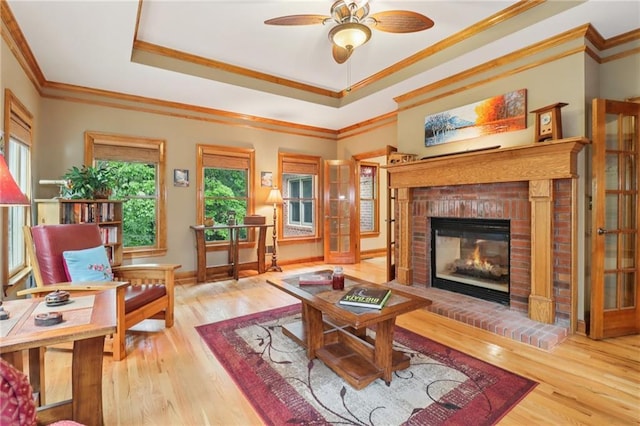 169 Robson Trl, Mcdonough, GA 30252 - living room with a fireplace, wood finished floors, ceiling fan, ornamental molding, and a tray ceiling