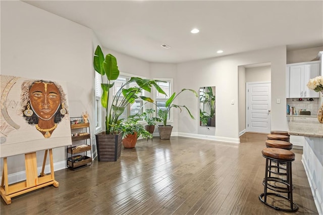 living area featuring baseboards, dark wood finished floors, and recessed lighting