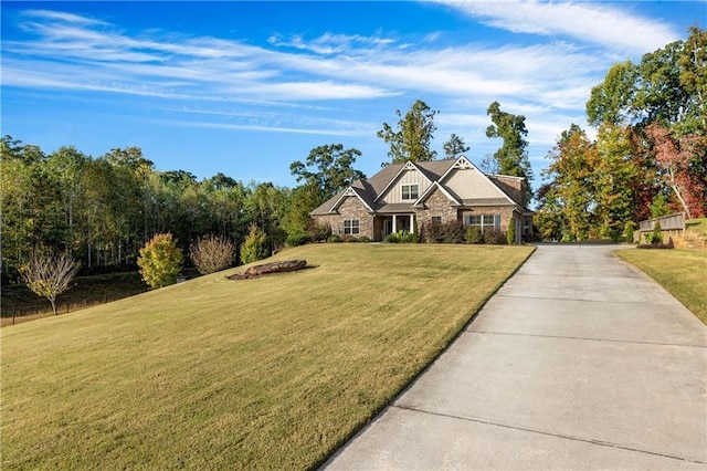 craftsman house featuring a front yard and stone siding