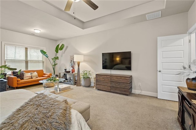 living area featuring a ceiling fan, visible vents, light carpet, and baseboards