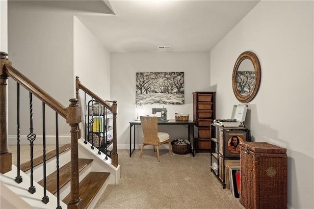 office area with baseboards, visible vents, and light colored carpet