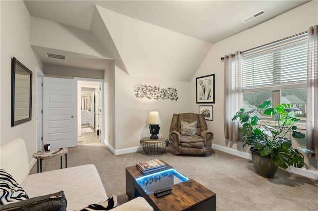 sitting room with lofted ceiling, baseboards, visible vents, and light colored carpet