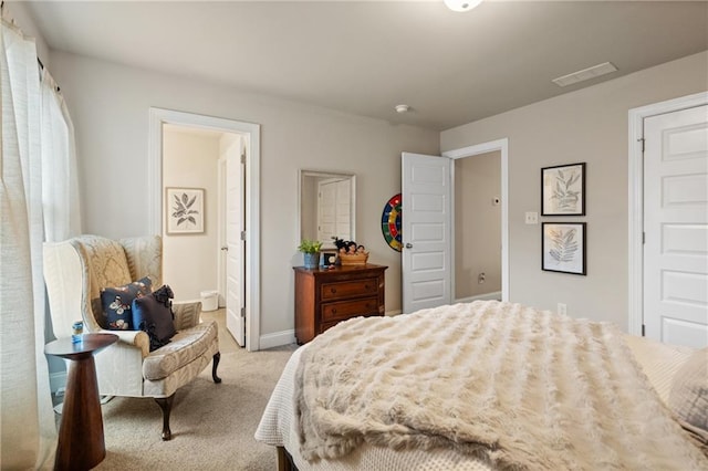 bedroom featuring light carpet, visible vents, baseboards, and ensuite bathroom