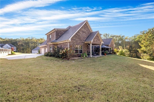 view of home's exterior with brick siding, concrete driveway, and a yard