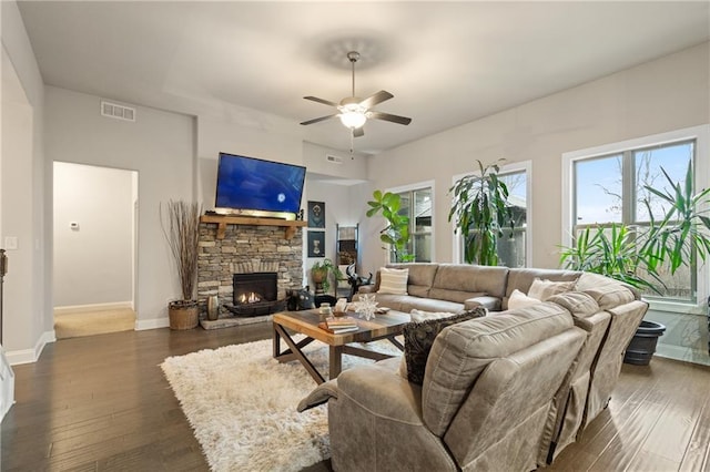 living area with a healthy amount of sunlight, a fireplace, visible vents, and dark wood finished floors