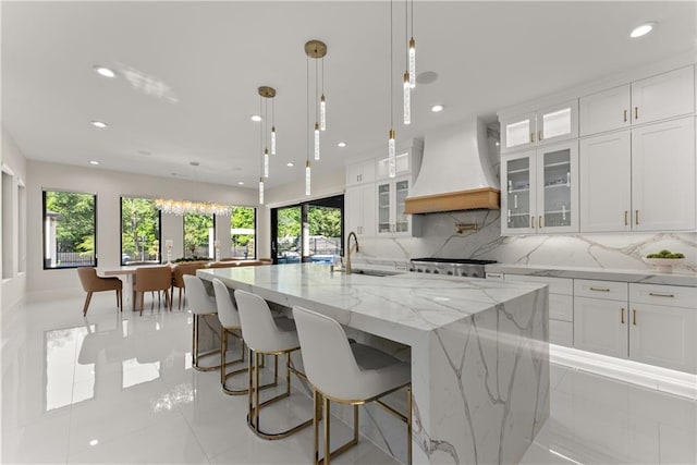 1336 Azalea Dr, Lawrenceville, GA 30043 - kitchen with custom exhaust hood, a large island with sink, white cabinetry, and recessed lighting