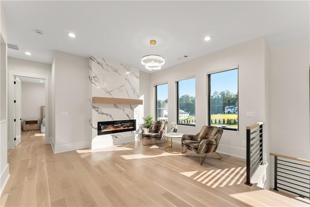 1336 Azalea Dr, Lawrenceville, GA 30043 - living area featuring a high end fireplace, light wood-type flooring, recessed lighting, baseboards, and a chandelier