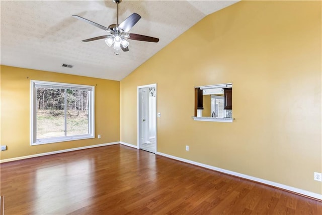 spare room featuring a ceiling fan, visible vents, baseboards, and wood finished floors