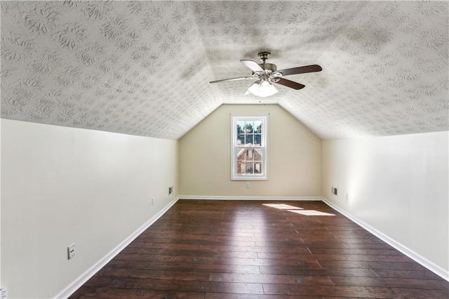 bonus room with vaulted ceiling, a textured ceiling, wood-type flooring, baseboards, and ceiling fan