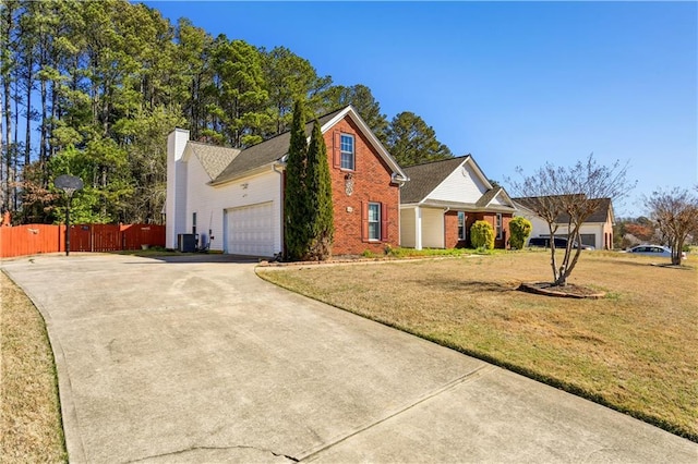 view of front of property with fence, an attached garage, driveway, a front yard, and brick siding