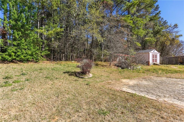 view of yard with fence, a shed, and an outdoor structure