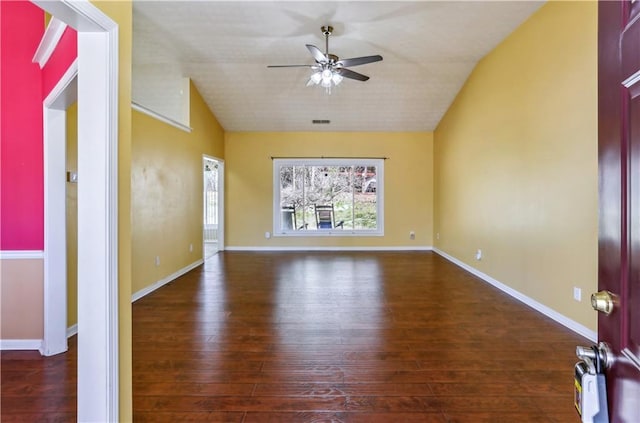spare room featuring baseboards, lofted ceiling, wood finished floors, and a ceiling fan