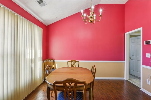 dining room featuring an inviting chandelier, hardwood / wood-style flooring, vaulted ceiling, and visible vents