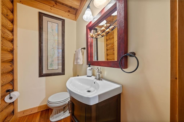 bathroom with beamed ceiling, vanity, toilet, and wood-type flooring