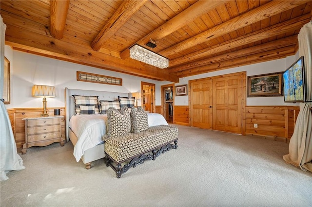 bedroom featuring wooden walls, beamed ceiling, wood ceiling, and carpet flooring