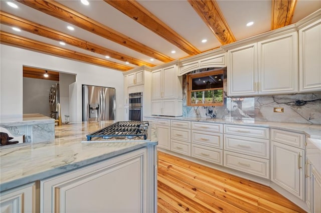 kitchen featuring light stone countertops, stainless steel appliances, light hardwood / wood-style flooring, beam ceiling, and backsplash