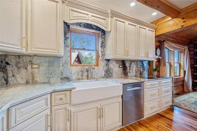 kitchen featuring light hardwood / wood-style floors, cream cabinetry, sink, backsplash, and stainless steel dishwasher