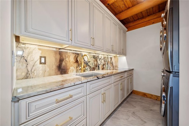 interior space with cabinets, sink, wood ceiling, and stacked washer and dryer