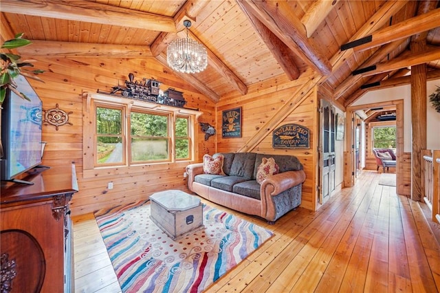 living room featuring vaulted ceiling with beams, wooden walls, a chandelier, wooden ceiling, and light hardwood / wood-style floors