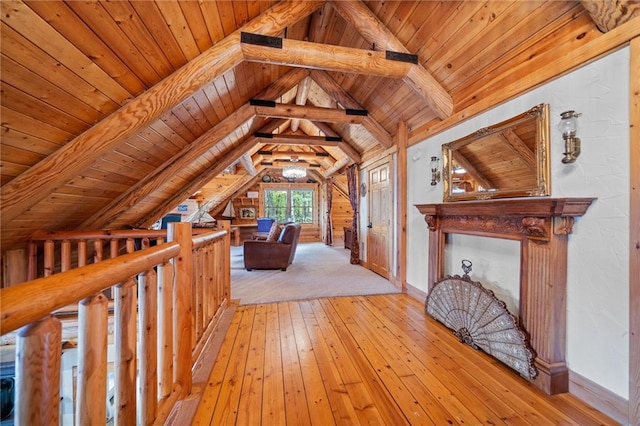 interior space with vaulted ceiling with beams, wood ceiling, and light hardwood / wood-style flooring