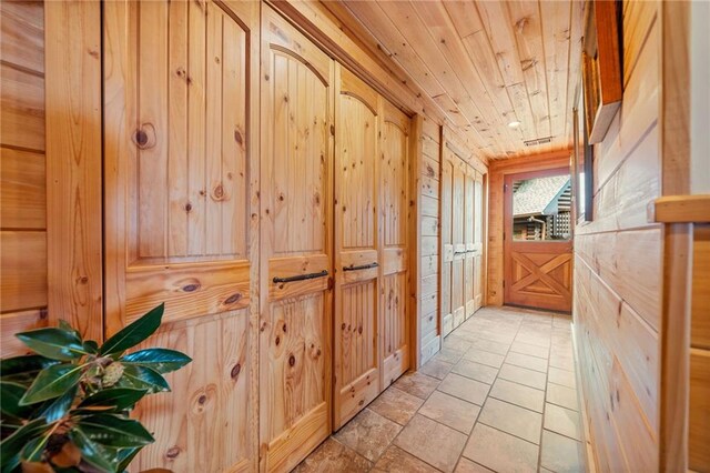 hallway with wooden walls and wood ceiling