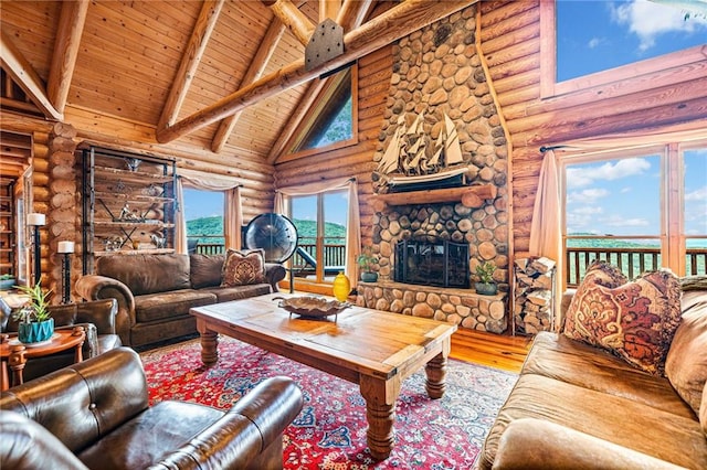 living room with hardwood / wood-style flooring, a fireplace, high vaulted ceiling, and log walls