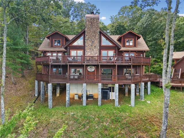 rear view of house with a deck and a lawn