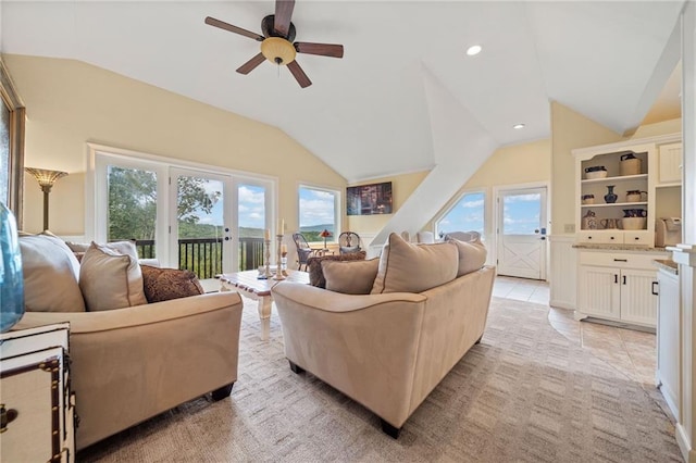 living room with ceiling fan, light tile patterned floors, and vaulted ceiling