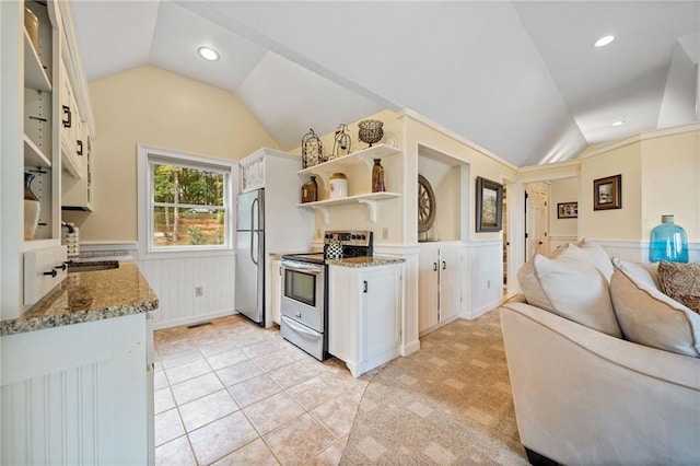 kitchen featuring stainless steel appliances, light stone countertops, lofted ceiling, and white cabinetry