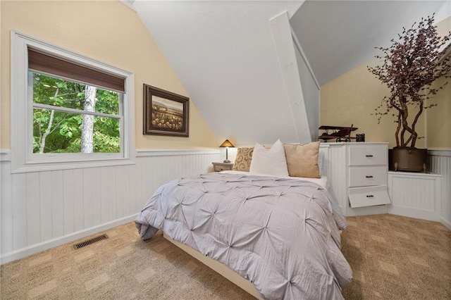 carpeted bedroom with lofted ceiling