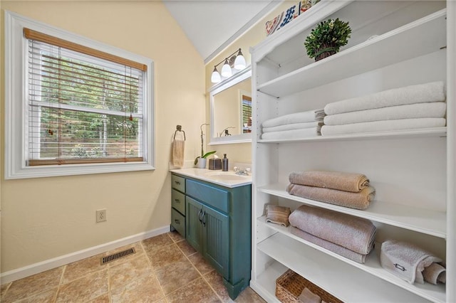 bathroom featuring vaulted ceiling and vanity