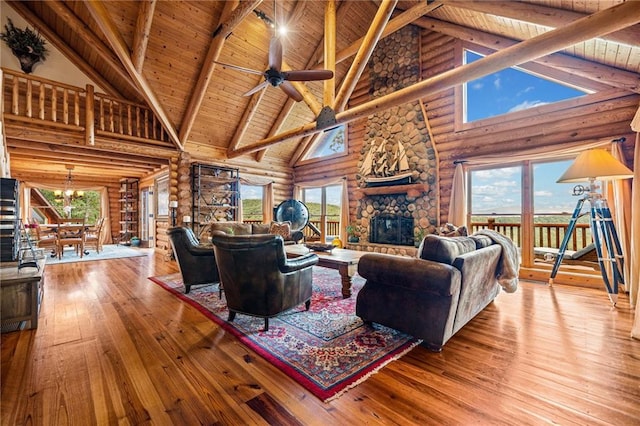 living room with a fireplace, light wood-type flooring, high vaulted ceiling, and a wealth of natural light