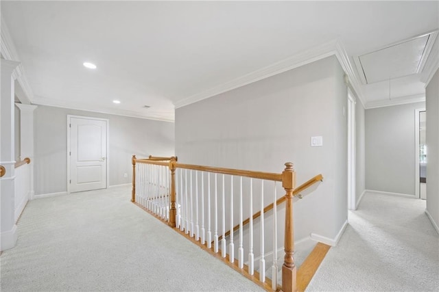 hall featuring baseboards, attic access, ornamental molding, carpet flooring, and an upstairs landing