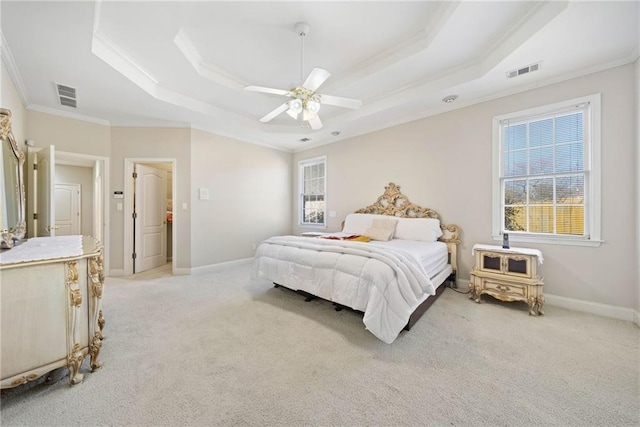 bedroom featuring visible vents, a raised ceiling, light colored carpet, and crown molding