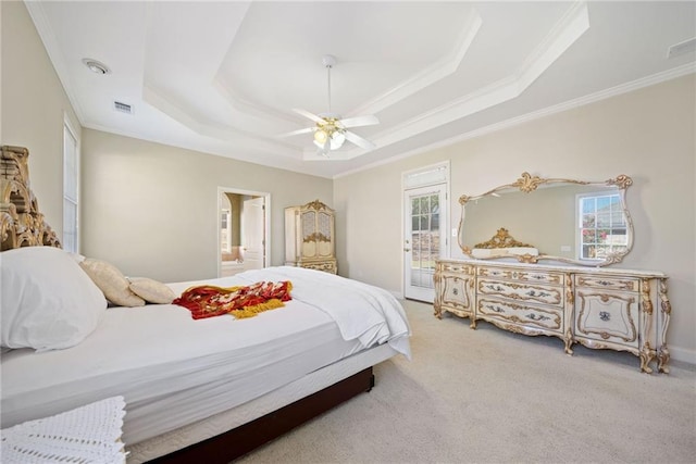 bedroom with visible vents, a tray ceiling, carpet flooring, crown molding, and access to exterior