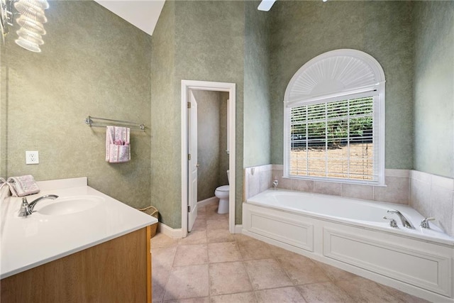 bathroom featuring vanity, a bath, a towering ceiling, tile patterned floors, and toilet