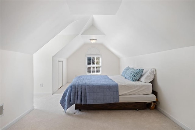 carpeted bedroom with baseboards and lofted ceiling