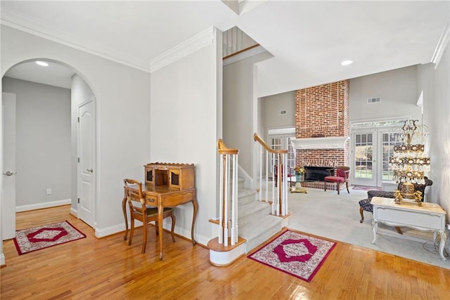 hallway featuring stairs, arched walkways, visible vents, and baseboards