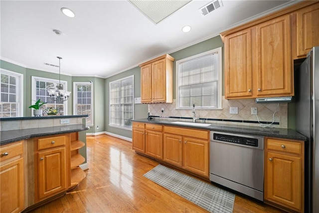 kitchen featuring visible vents, a sink, stainless steel appliances, light wood-style floors, and a notable chandelier