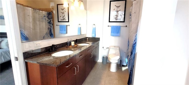 bathroom with vanity, connected bathroom, toilet, and tile patterned floors