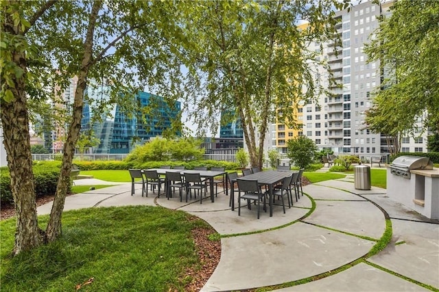 surrounding community featuring a view of city, a yard, and exterior kitchen