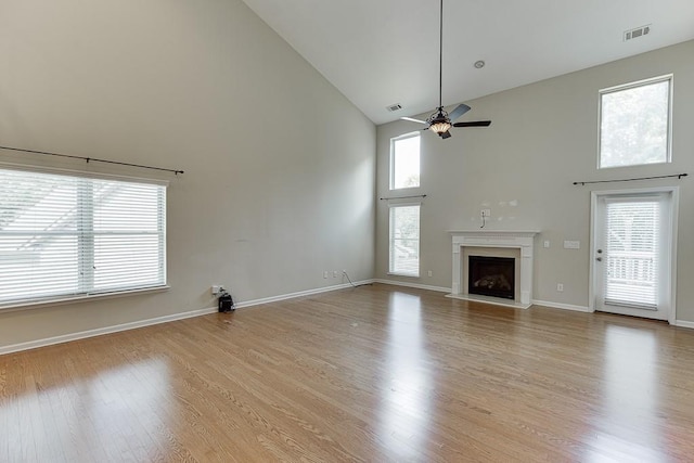 7719 Copper Kettle Way, Flowery Branch, GA 30542 - unfurnished living room with high vaulted ceiling, a ceiling fan, a fireplace with raised hearth, and light wood finished floors