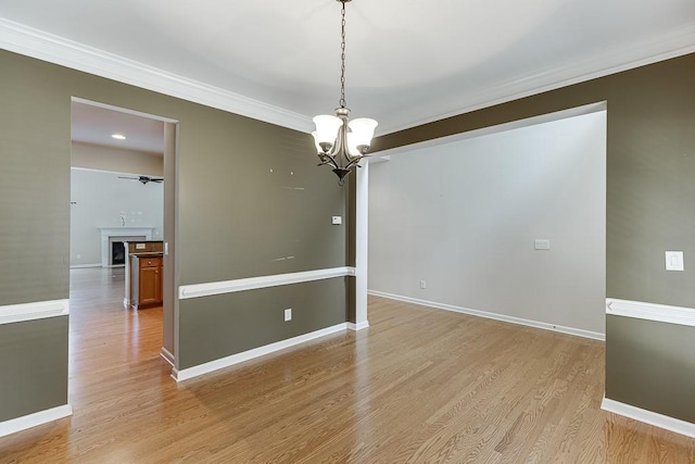 7719 Copper Kettle Way, Flowery Branch, GA 30542 - spare room with a chandelier, ornamental molding, light wood-type flooring, and a fireplace