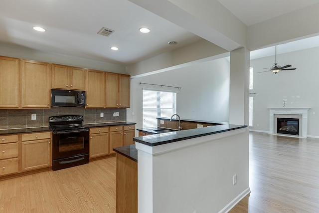7719 Copper Kettle Way, Flowery Branch, GA 30542 - kitchen featuring black appliances, light wood-style flooring, tasteful backsplash, a ceiling fan, and a glass covered fireplace