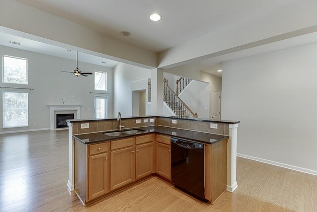 7719 Copper Kettle Way, Flowery Branch, GA 30542 - kitchen featuring black dishwasher, light wood-style flooring, a fireplace, open floor plan, and a ceiling fan