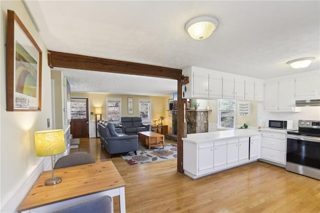 kitchen with under cabinet range hood, electric range, white cabinets, and black microwave