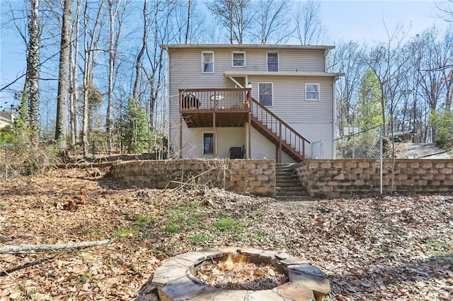 back of property featuring stairs, a fire pit, and a wooden deck